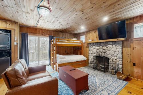a living room with a bed and a fireplace at Fornuto Cabin in Wardsboro
