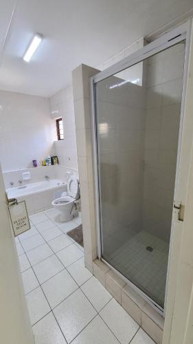 a bathroom with a shower and a toilet at Light Hall in Johannesburg