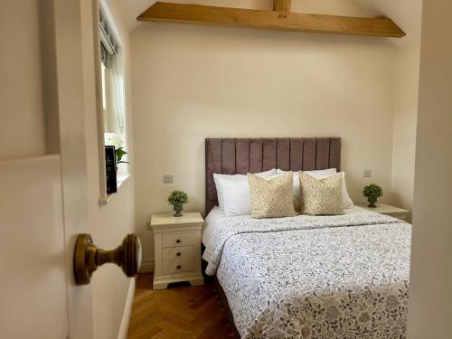 a bedroom with a bed with a wooden headboard and a window at Luxury cottage for 2 in Castleton - Peak District retreat - Panoramic Views & Log burner in Castleton