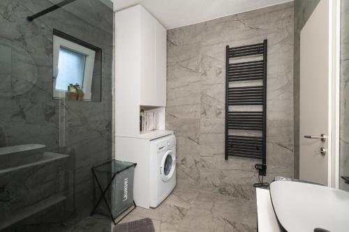 a bathroom with a washing machine and a sink at Villa The Rock in Unešić