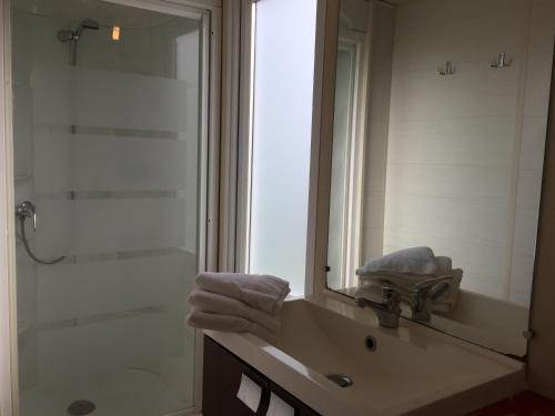 une salle de bain avec un lavabo, une douche et un miroir dans l'établissement Camping de l'Eouviere, à Montmeyan