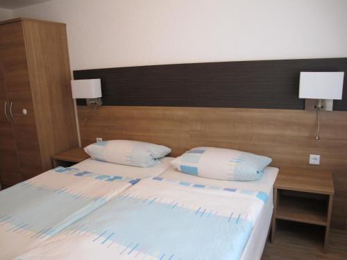 een slaapkamer met een groot bed met 2 kussens bij Gasthaus Römer in Haigerloch