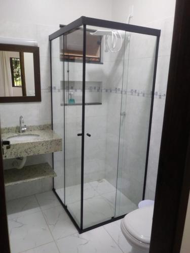 a bathroom with a glass shower and a toilet at Hospedagem Na Rota do Enxaimel - Andar Térreo ou Superior - Alles Acer in Pomerode