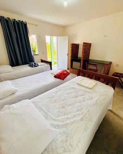a hotel room with two beds and a television at Pousada Padre Pio CE in São Benedito
