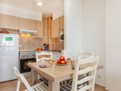 a kitchen with a wooden table and white appliances at Apartment Vermell-8 by Interhome in Platja d'Aro