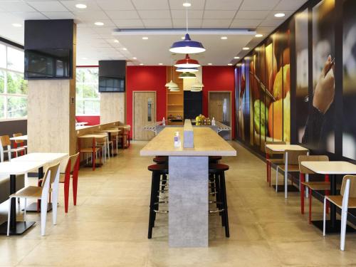 a dining area with tables and chairs in a restaurant at Ibis Guaxupe in Guaxupé