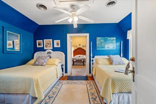 a blue bedroom with two beds and a ceiling fan at Longacre of Appomattox in Appomattox