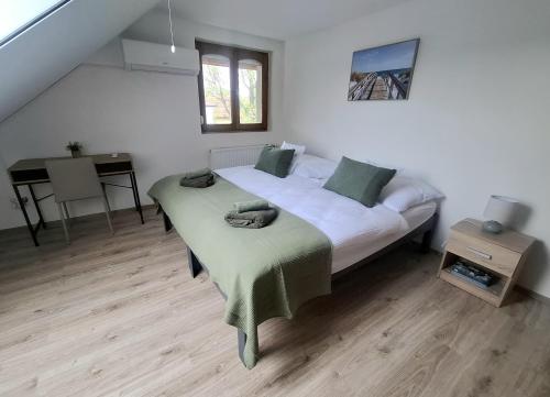 a bedroom with two beds and a desk in it at Green Home Apartman in Nemesvámos