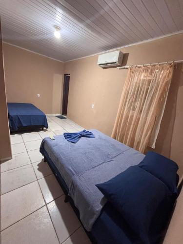 a bedroom with two beds in a room with a ceiling at Refúgio da Sombra House in Rondonópolis