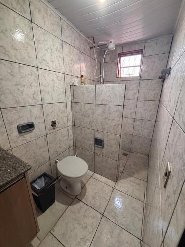 a bathroom with a toilet and a shower at Refúgio da Sombra House in Rondonópolis