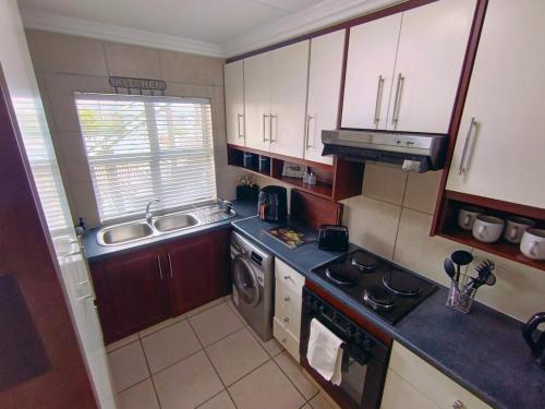 a small kitchen with a sink and a stove at 6 Vasco Mews in Mossel Bay