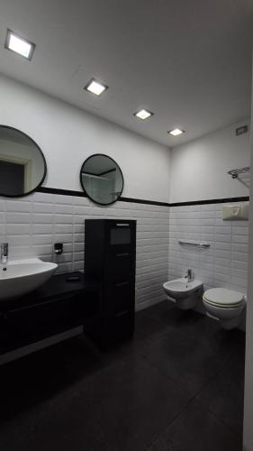 a bathroom with two sinks and a toilet and mirrors at Casa Mia in Cosenza