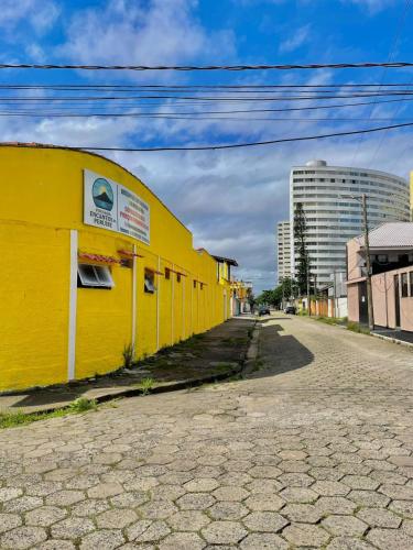 a yellow building on the side of a street at Pousada ENCANTOS de PERUÍBE in Peruíbe