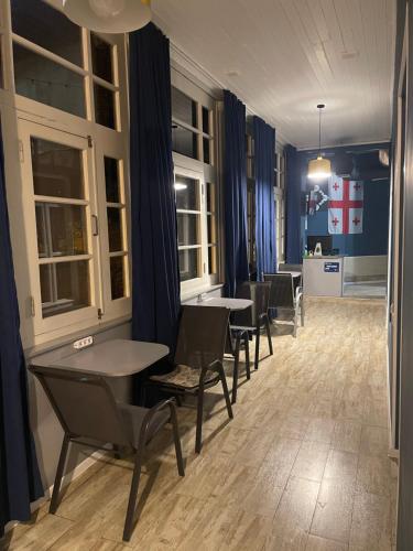 a dining room with tables and chairs and blue walls at Hostel Room 110 in Tbilisi City