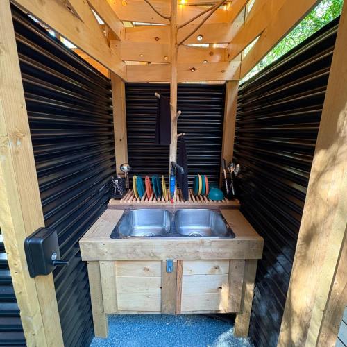 ein Badezimmer mit einem Holzwaschbecken in einer Garage in der Unterkunft Basecamp3105 in Sooke