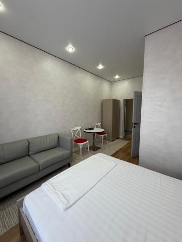 a bedroom with a bed and a couch and a table at Comfort Altyn-Emel in Kalīnīno