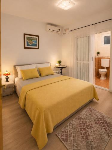 a bedroom with a large bed and a bathroom at Apartments Nuhi in Ulcinj