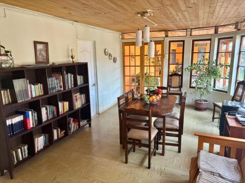 a dining room with a table and bookshelves at Alojamiento La Rosa in Combarbalá