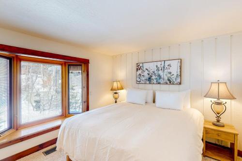 a bedroom with a white bed and two windows at Ideal in Idaho in Ketchum