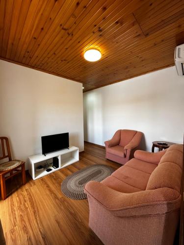 a living room with a couch and a tv at Ron House in São Caetano