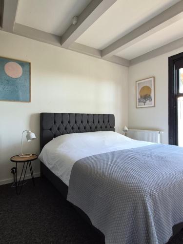 a bedroom with a large bed and a table at De Bloesemstee - Rustic Manor Farmhouse The Netherlands in Ruinerwold