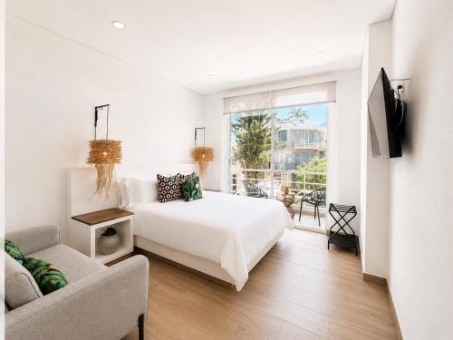 a white bedroom with a bed and a couch at Palmará Hotel in Villeta