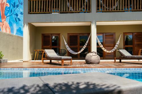 a swimming pool with two chairs and a house at Vila Tuga in Prea