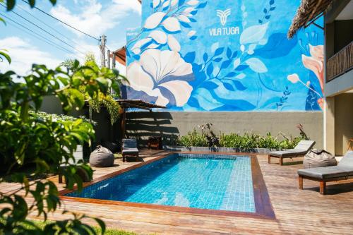 a swimming pool in front of a wall with a mural at Vila Tuga in Prea
