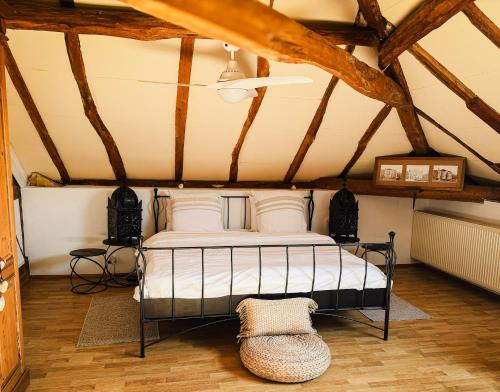 a bedroom with a bed in a room with wooden ceilings at En bord de rivière in Casseneuil
