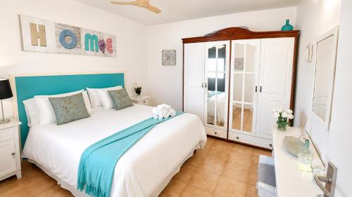 a bedroom with a white bed with a blue headboard at Primavera Pool Paradise in Arona