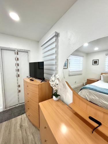 a bedroom with a bed and a tv on a wooden dresser at Sanctuary Retreat Florida HardRock in Hollywood