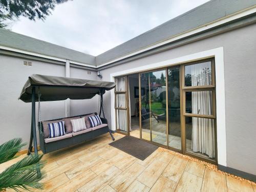 a patio with an umbrella and a bench on a deck at Falcon Guest House in Harare