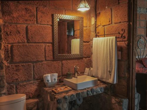 ein Badezimmer mit Waschbecken und einer Ziegelwand in der Unterkunft Armadillo Mágico in Armadillo