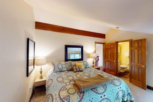 a bedroom with a large bed and a bathroom at Bellflower Trout House in Vail