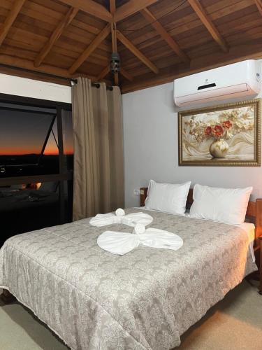 a bedroom with a bed with two towels on it at Pousada São Bento in Cunha