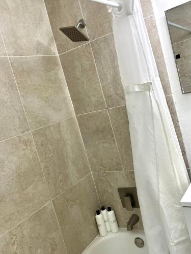 a bathroom with a shower with a tub and a toilet at Sanctuary Retreat Florida HardRock in Hollywood
