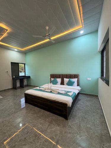a bedroom with a bed with a ceiling at Rainbow Cottage Stays in Kānha
