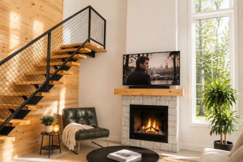 a living room with a fireplace with a tv above it at Spa & Lili Lake - Le Borea in Chertsey