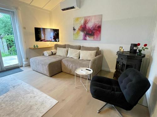 a living room with a couch and a table at Dune Nest 233 - beautiful house near beach - up to 4 guests with garden, parking, WLAN in Bredene