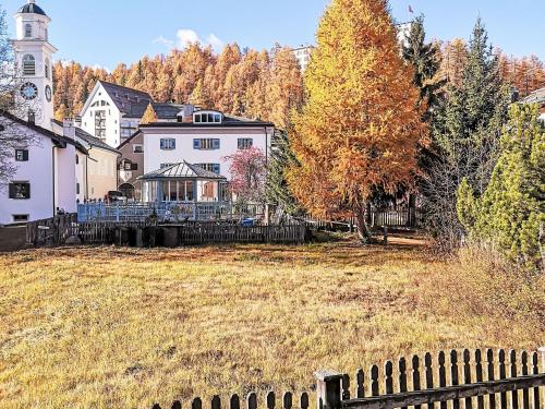 a large yard with a house and a fence at Apartment 4 Bettwohnung by Interhome in Sils Maria