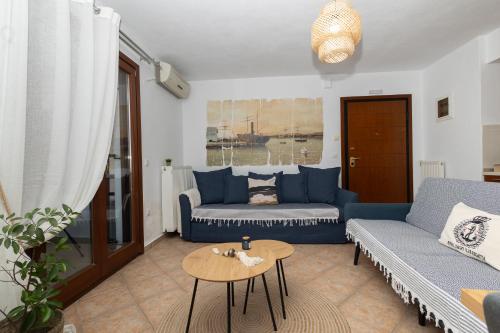 a living room with blue couches and a table at StefanoS Blue Horizon in Afitos