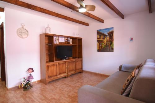 a living room with a couch and a flat screen tv at Villa Florymar a 12 minutos del aeropuerto in Ingenio