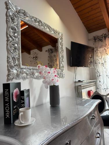 a table with a vase of flowers and a mirror at Il sogno di Eda in Mozzate