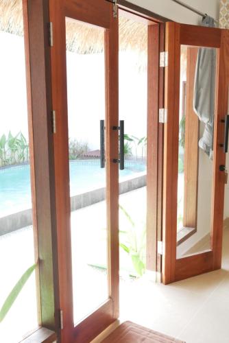 an open glass door with a view of the ocean at Golden Villa in Gili Trawangan