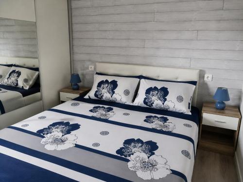 a bedroom with a bed with blue and white sheets and pillows at Les Logis de la Seugne in Saint-Germain-de-Lusignan