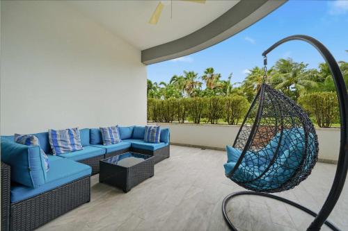 a living room with blue couches and a swing at Cable Beach Condo Large private patio with BBQ in Nassau