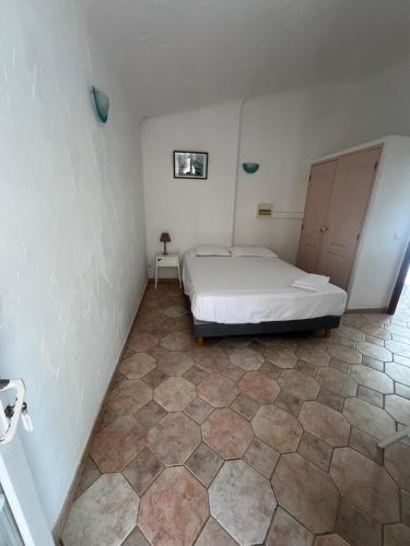 a bedroom with a bed and a tiled floor at Residence La Beloutiere in Porto-Vecchio