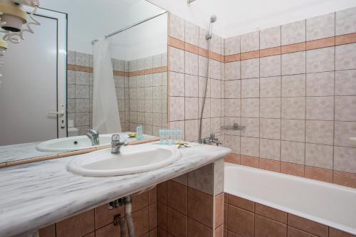 a bathroom with a sink and a tub at Diagoras Hotel All Inclusive in Faliraki