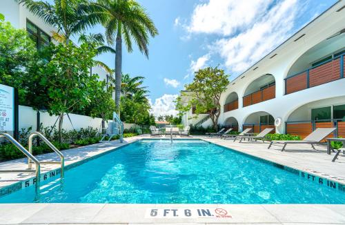 a swimming pool in front of a building at The Mizner Pool Suite - Boca Beachside in Boca Raton