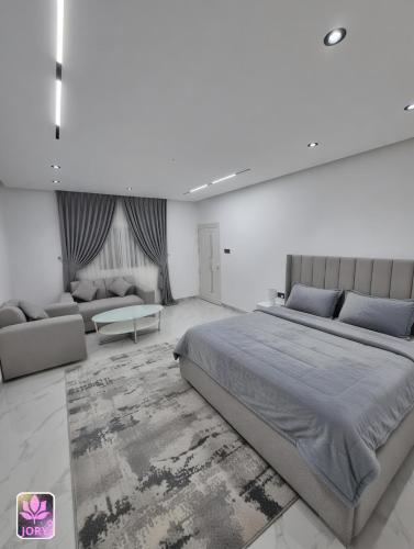 a bedroom with a large bed and a couch at شاليه روز حتا - Hatta Rose Chalet in Hatta